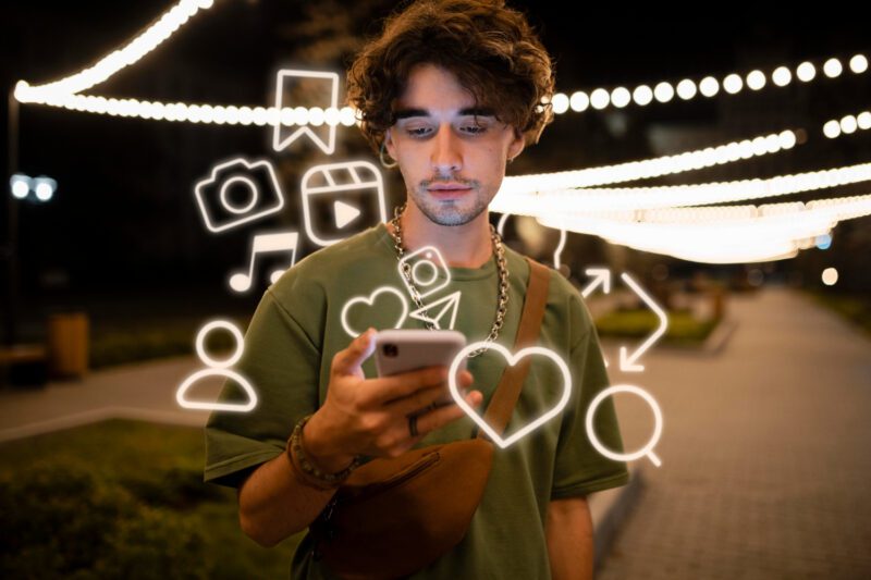 Žmogus naudojantis nešiojamą kompiuterį, supamas skaitmeninių ikonų ir socialinių tinklų simbolių, iliustruojantis sąmoningą interneto vartojimą.