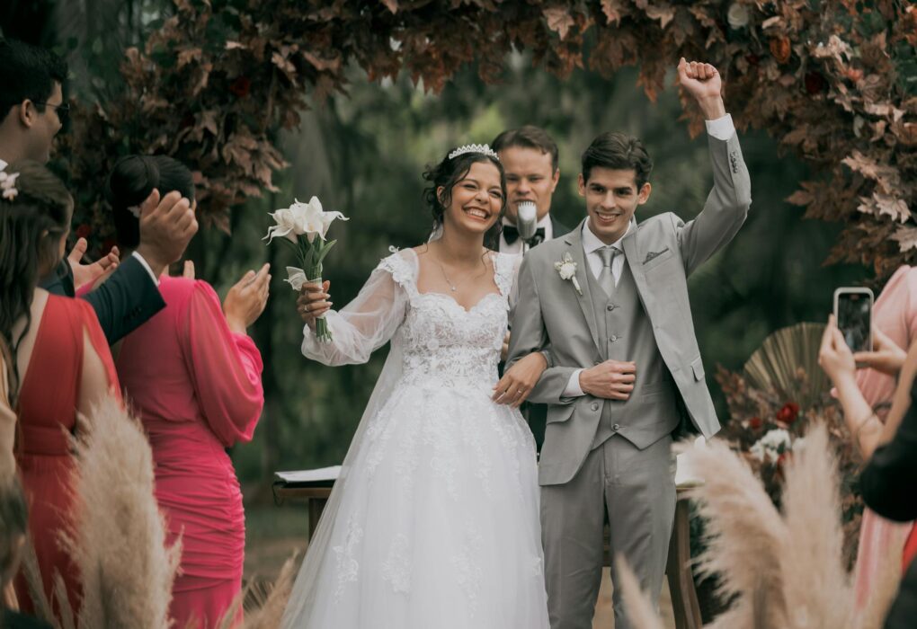 Vestuvių vedėjas bendrauja su skirtingų kartų šventės svečiais prie stalų.