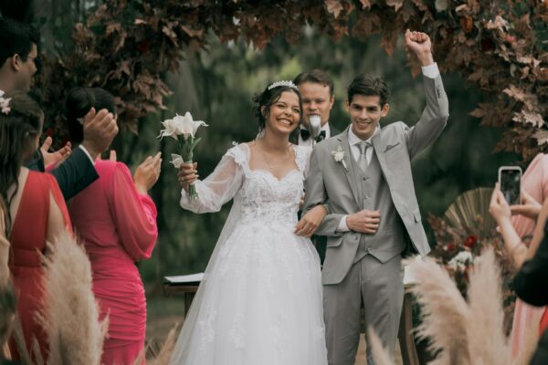 Vestuvių vedėjas bendrauja su skirtingų kartų šventės svečiais prie stalų.